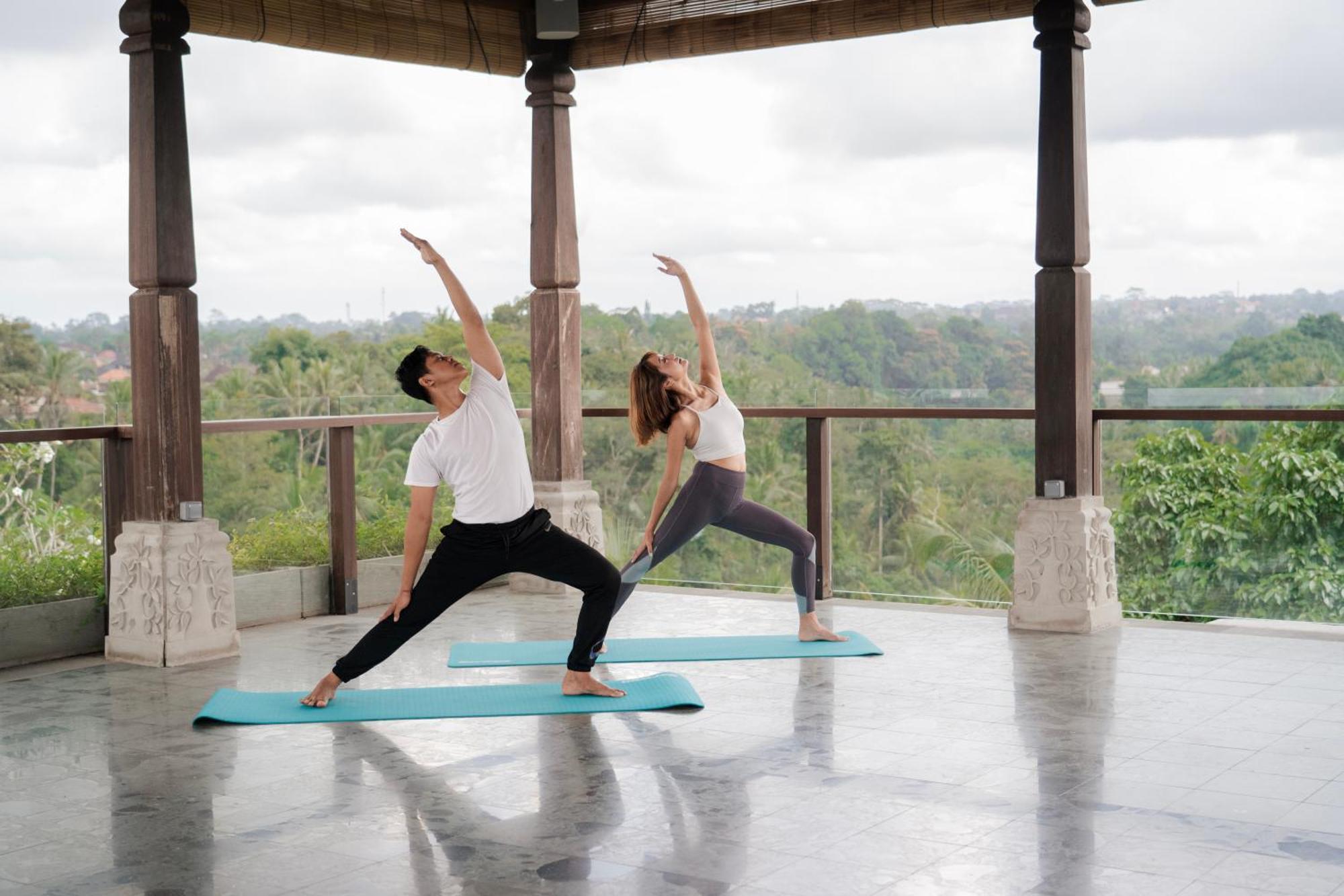 Adiwana Bisma Hotell Ubud Exteriör bild A couple practicing yoga